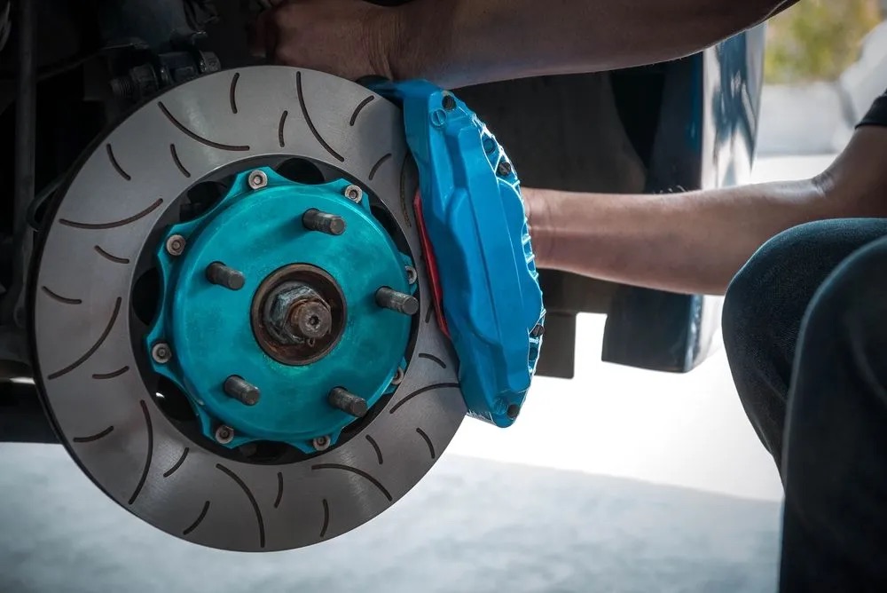 Technician servicing a standard brake rotor and caliper